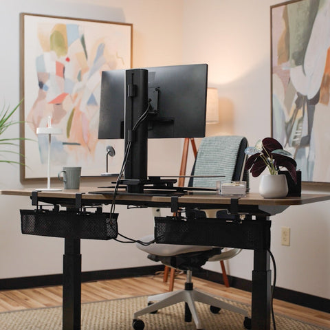 Home office setup with a standing desk, computer monitors, and decorative elements.